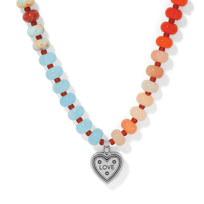 Brighton beaded necklace with blue, peach, and orange stone beads and silver-tone love heart pendant on a white background