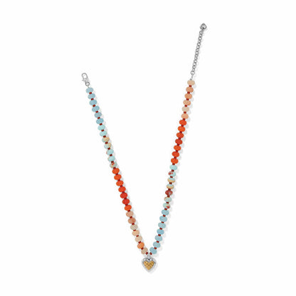 Brighton beaded necklace with aqua, orange, and peach beads and two-tone heart pendant on a white background