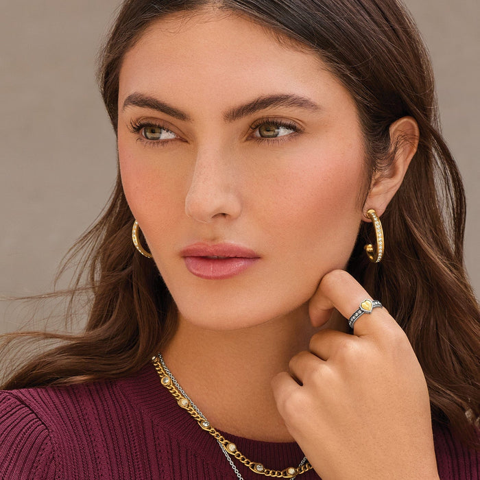 Model wearing Brighton two-tone crystal hoop earrings with coordinating Brighton accessories including a heart ring and layered necklace