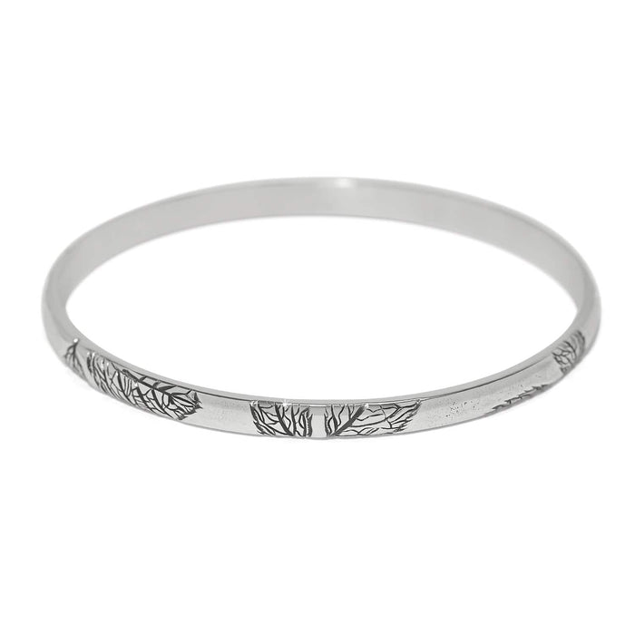 Brighton bangle bracelet with silver-plated finish and engraved tree branch design along the band on a white background