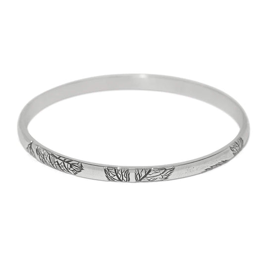 Brighton bangle bracelet with silver-plated finish and engraved tree branch design along the band on a white background