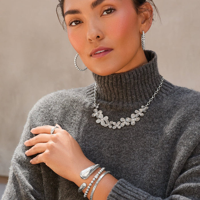 Model wearing a Brighton silver-plated floral necklace with crystal accents and coordinating Brighton accessories