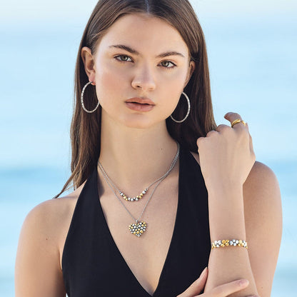 Model wearing a Brighton two-tone heart pendant necklace with beaded design and coordinating Brighton accessories