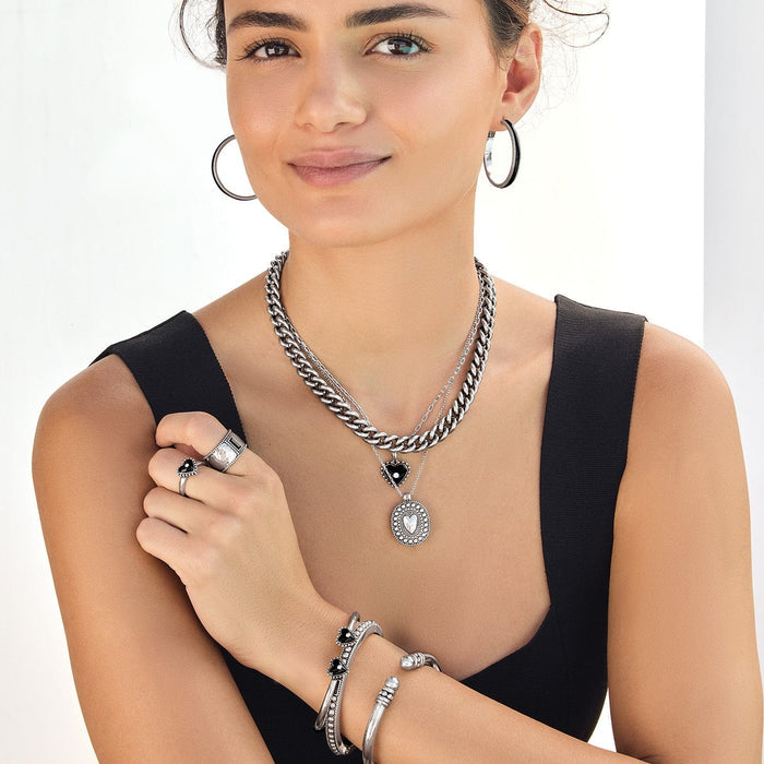 Model wearing Brighton silver-plated layered chain necklace with heart and oval pendants and coordinating Brighton accessories