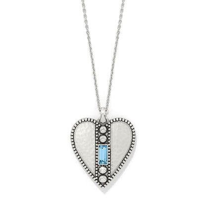 Brighton heart pendant necklace with hammered silver-plated finish, beaded edges, and blue crystal baguette on a white background