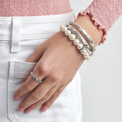 Model wearing Brighton silver-plated bracelets with pearl beads and engraved bar, paired with a silver-plated beaded ring