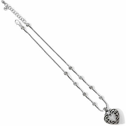Brighton silver-plated pendant necklace with ornate scrollwork heart, crystal pavé accents, and beaded chain on a white background