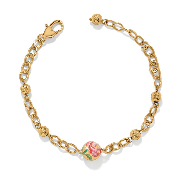 Brighton gold-plated chain bracelet with floral enamel bead, beaded stations, and heart-shaped clasp on a white background