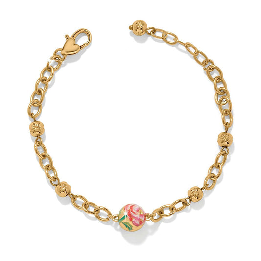 Brighton gold-plated chain bracelet with floral enamel bead, beaded stations, and heart-shaped clasp on a white background