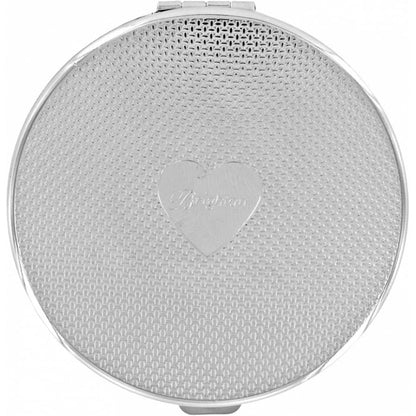 Brighton round silver-tone compact with woven texture pattern and engraved heart emblem at center on a white background