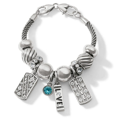 Brighton charm bracelet with silver-plated beads, crystal accents, blue stone, and Blessed, Love, Live charms on a white background
