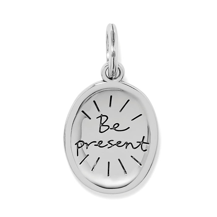 Brighton oval charm with engraved Be Present script and silver-plated finish with radiating lines on a white background