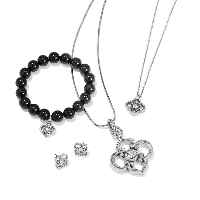 Brighton silver-plated jewelry set styled with black beaded bracelet, quatrefoil pendant necklaces, and matching crystal stud earrings