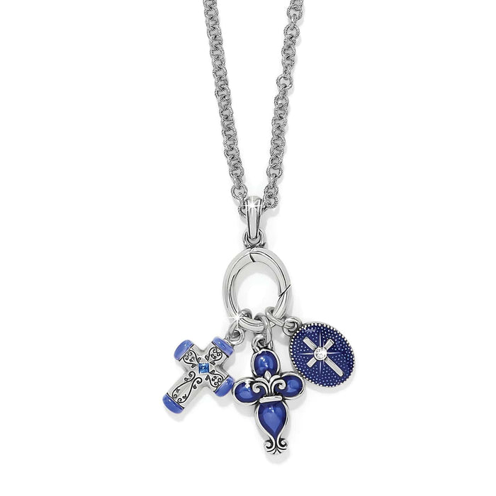 Brighton charm necklace with silver-plated cross, blue enamel fleur-de-lis, and crystal medallion charms on a white background