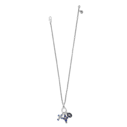 Brighton silver-plated charm necklace with blue enamel cross, fleur-de-lis, and crystal medallion pendants on a white background