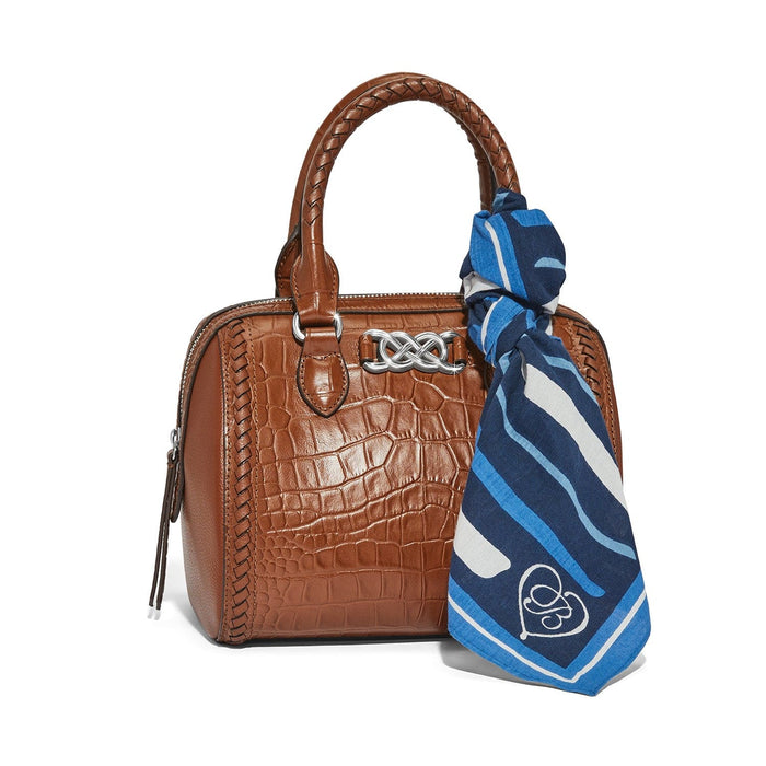 Brighton handbag in brown crocodile-embossed leather with braided handles, silver-tone knot accent, and blue striped scarf on a white background